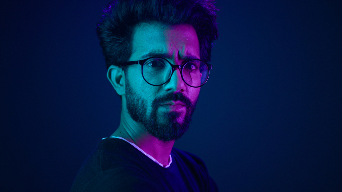 Engineer wearing glasses frowning in dark setting